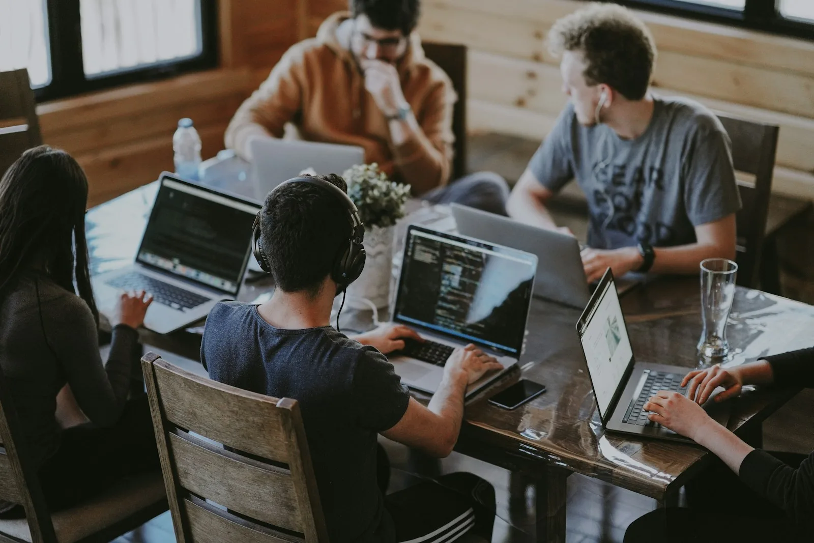 Colleagues working together around laptops at a table